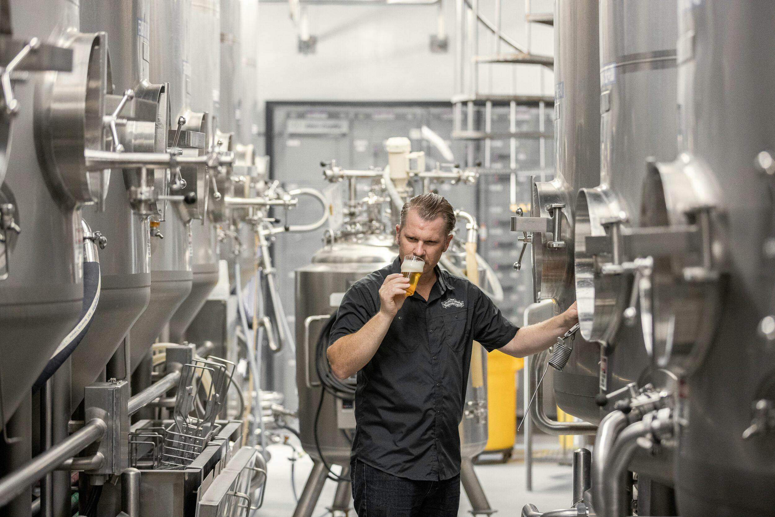 A Sierra Nevada brewer smelling a sample of beer in the fermentation cellar