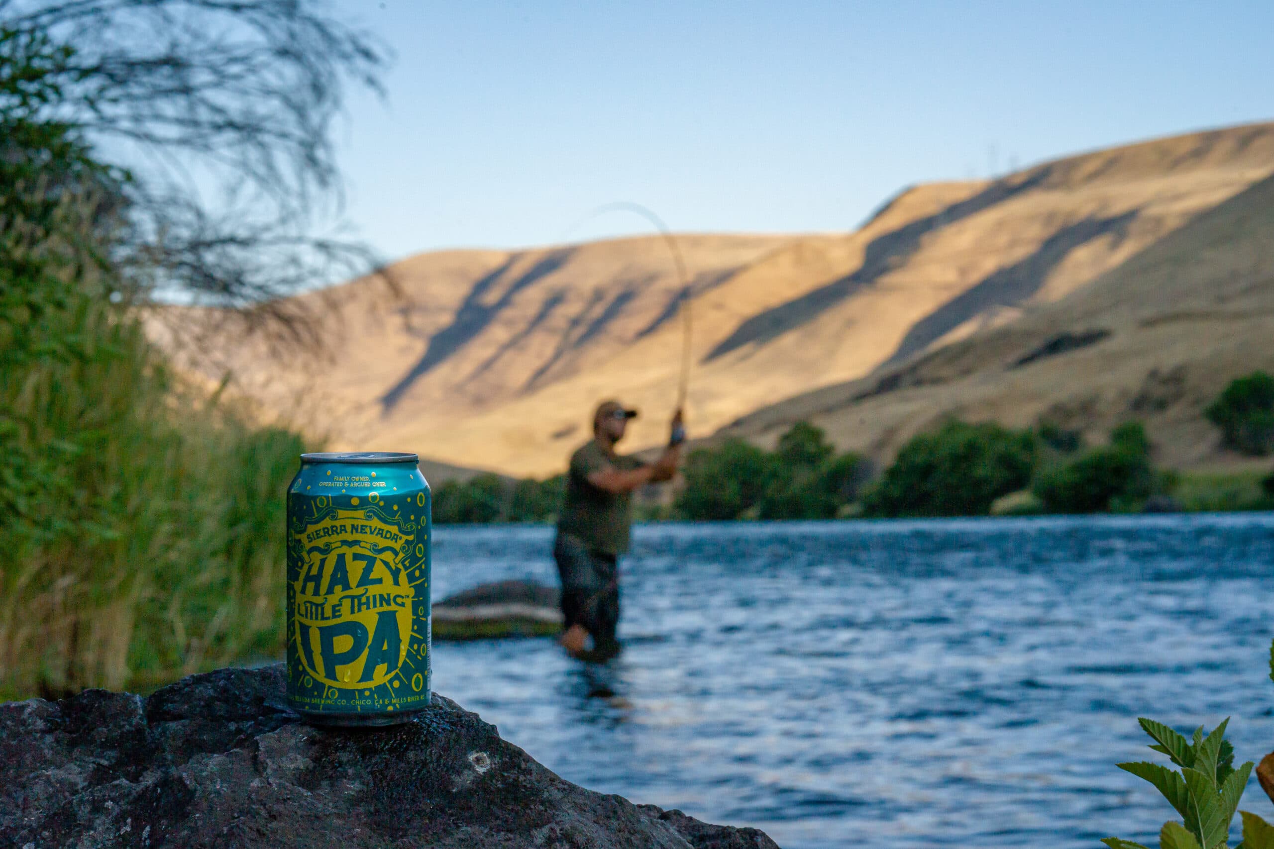 Hazy Little Thing IPA beer can by river with fisher man