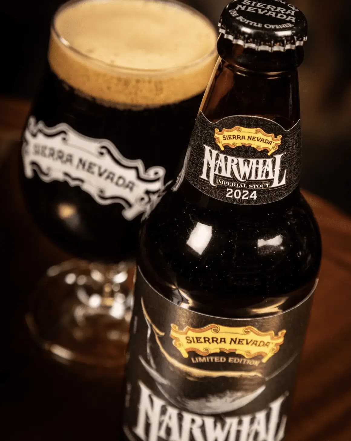 A close-up shot of a pint of Narwhal in a glass, sitting next to the bottle