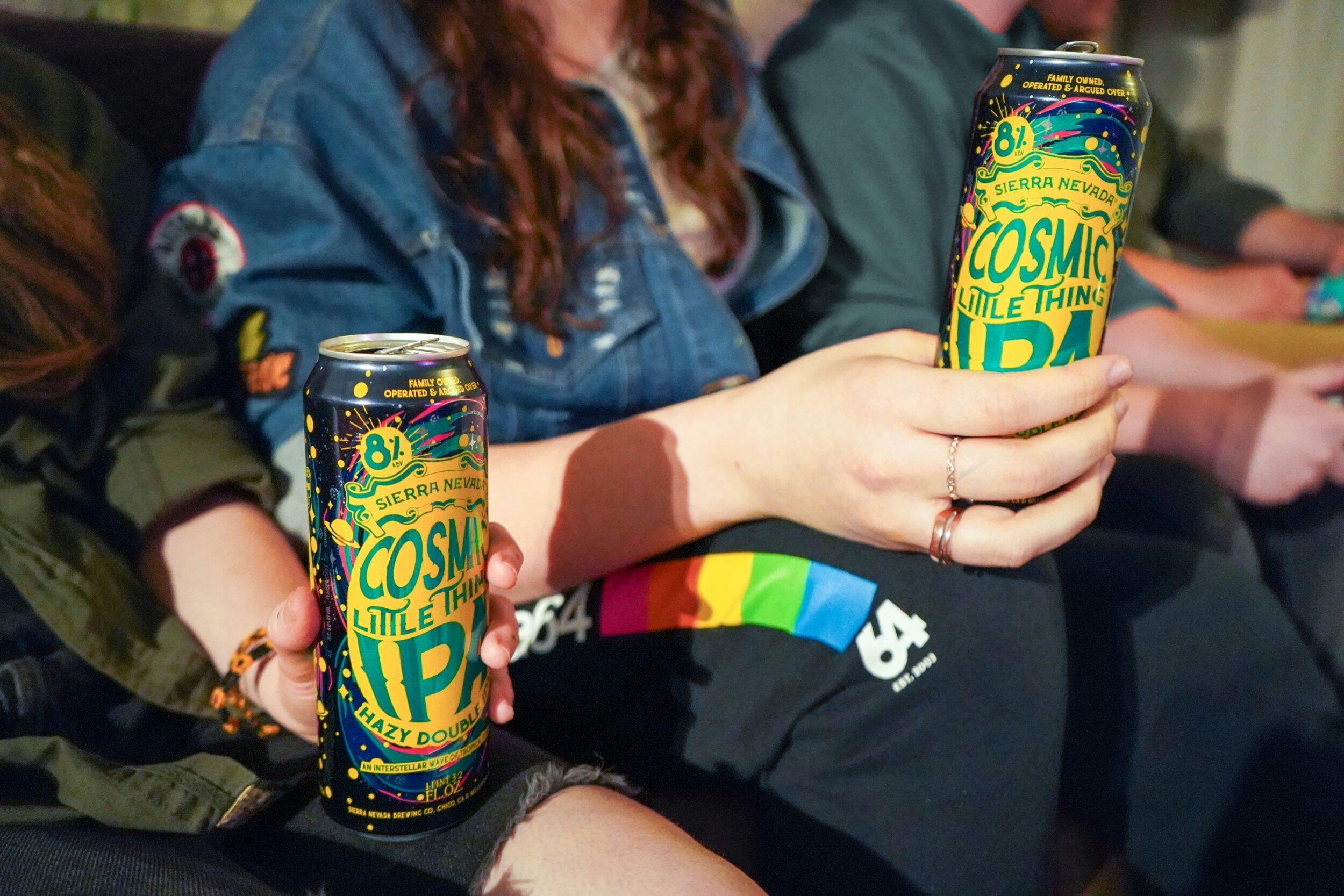 Cosmic Little Thing cans held by friends sitting on couch