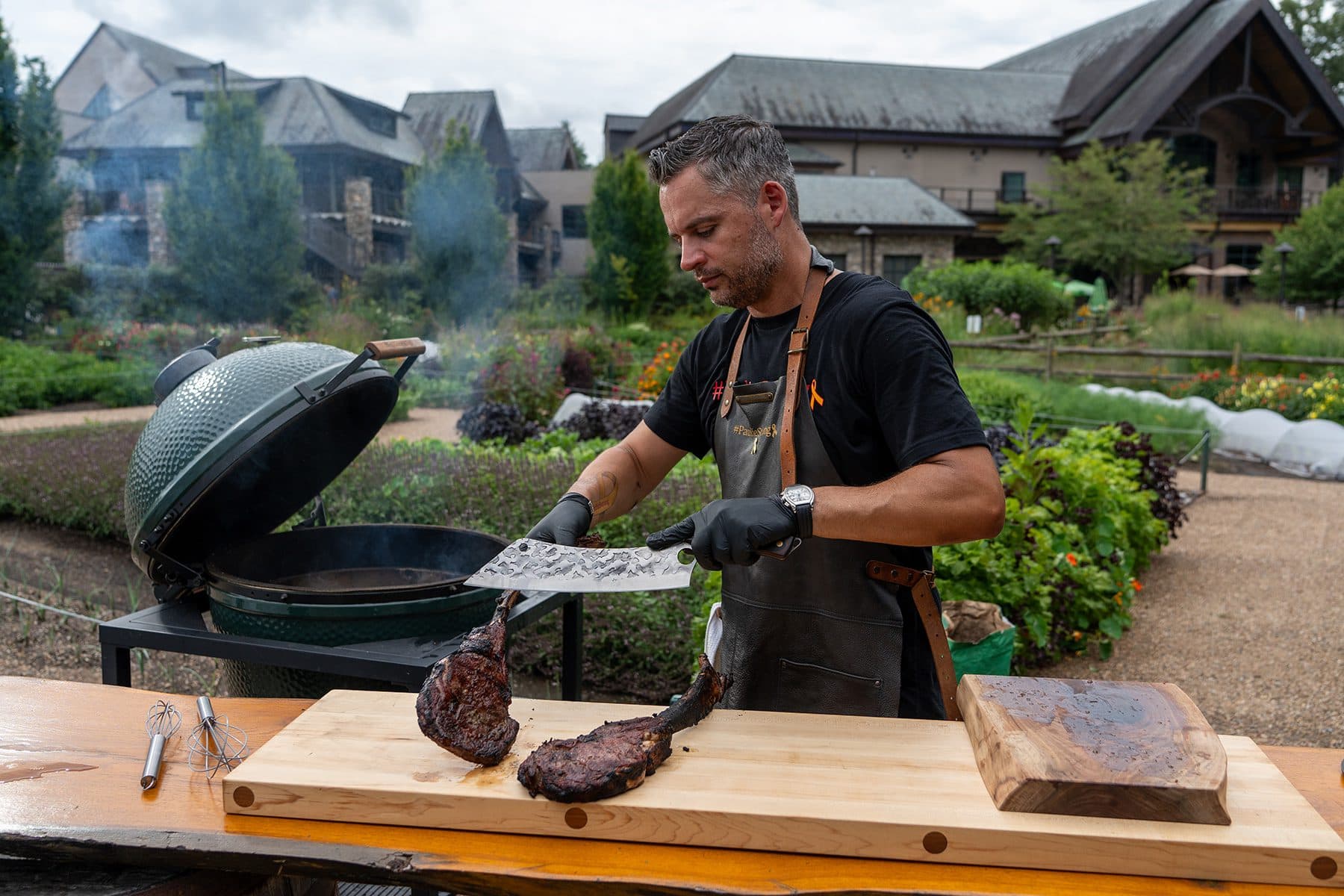 Grillmaster Paul Jimenez cutting a freshly grilled tomahawk steak outside the Sierra Nevada brewery