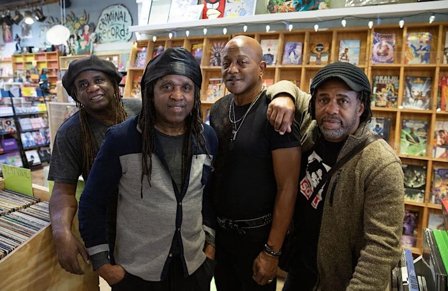 Victor Wooten band posing for a picture in a record shop