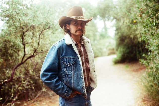 Jesse Daniels standing on a trail in the woods