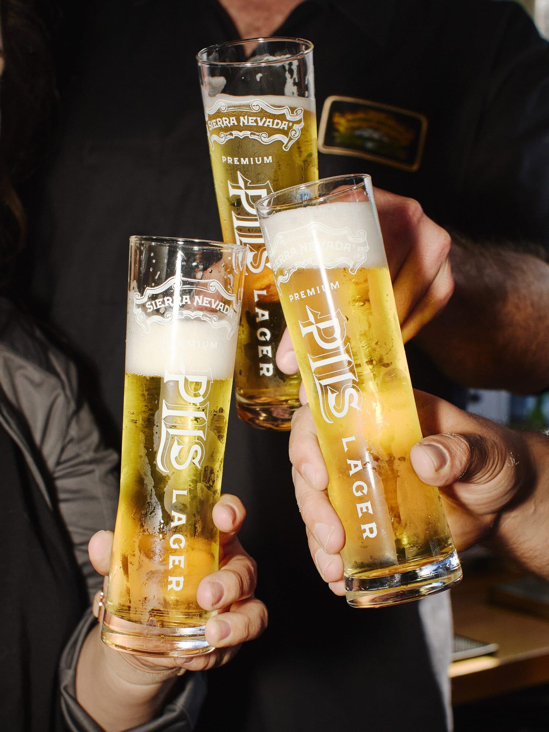Glasses with Sierra Nevada PILS being cheersed