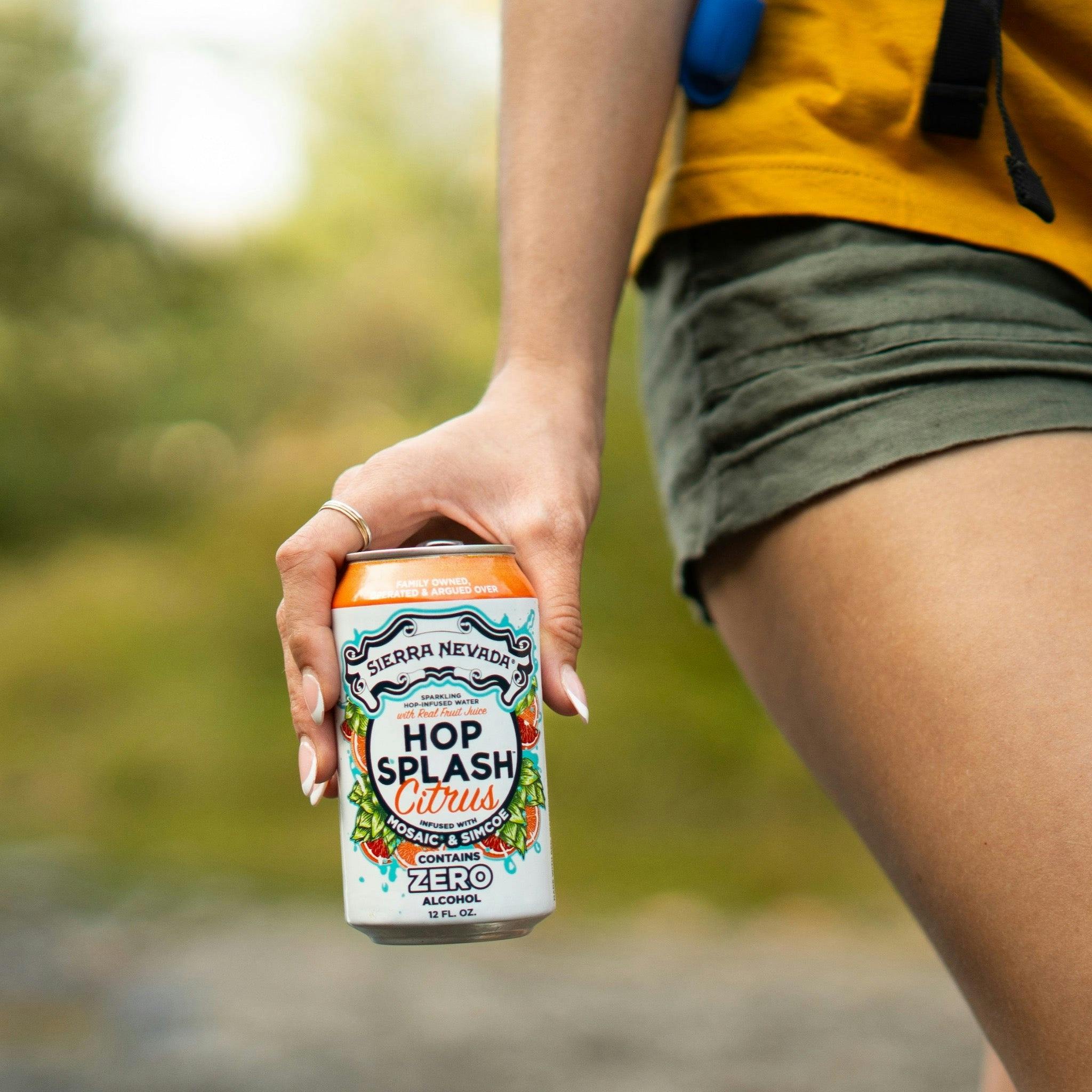 Sierra Nevada Brewing Co. Hop Splash Citrus Non-Alcoholic Sparkling Hop Water - A female hiker carries a can of refreshing Hop Splash Citrus in her hand