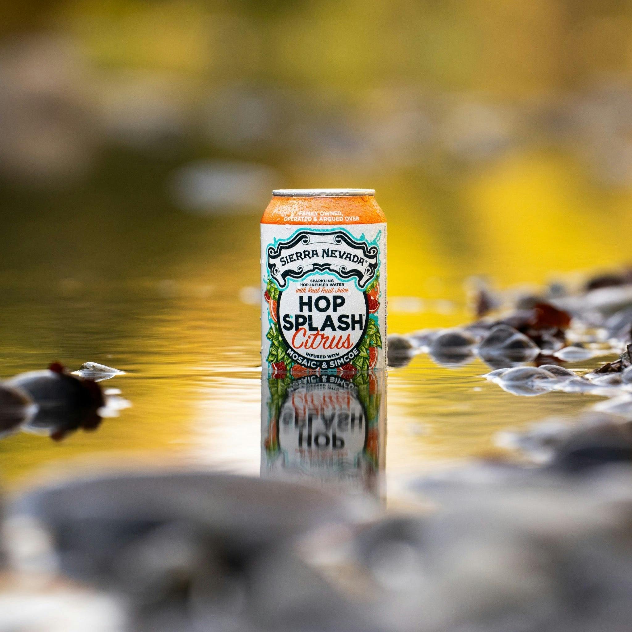 Sierra Nevada Brewing Co. Hop Splash Citrus Non-Alcoholic Sparkling Hop Water - A cold can of Hop Splash Citrus sitting in a shallow pool of water surrounded by river rocks