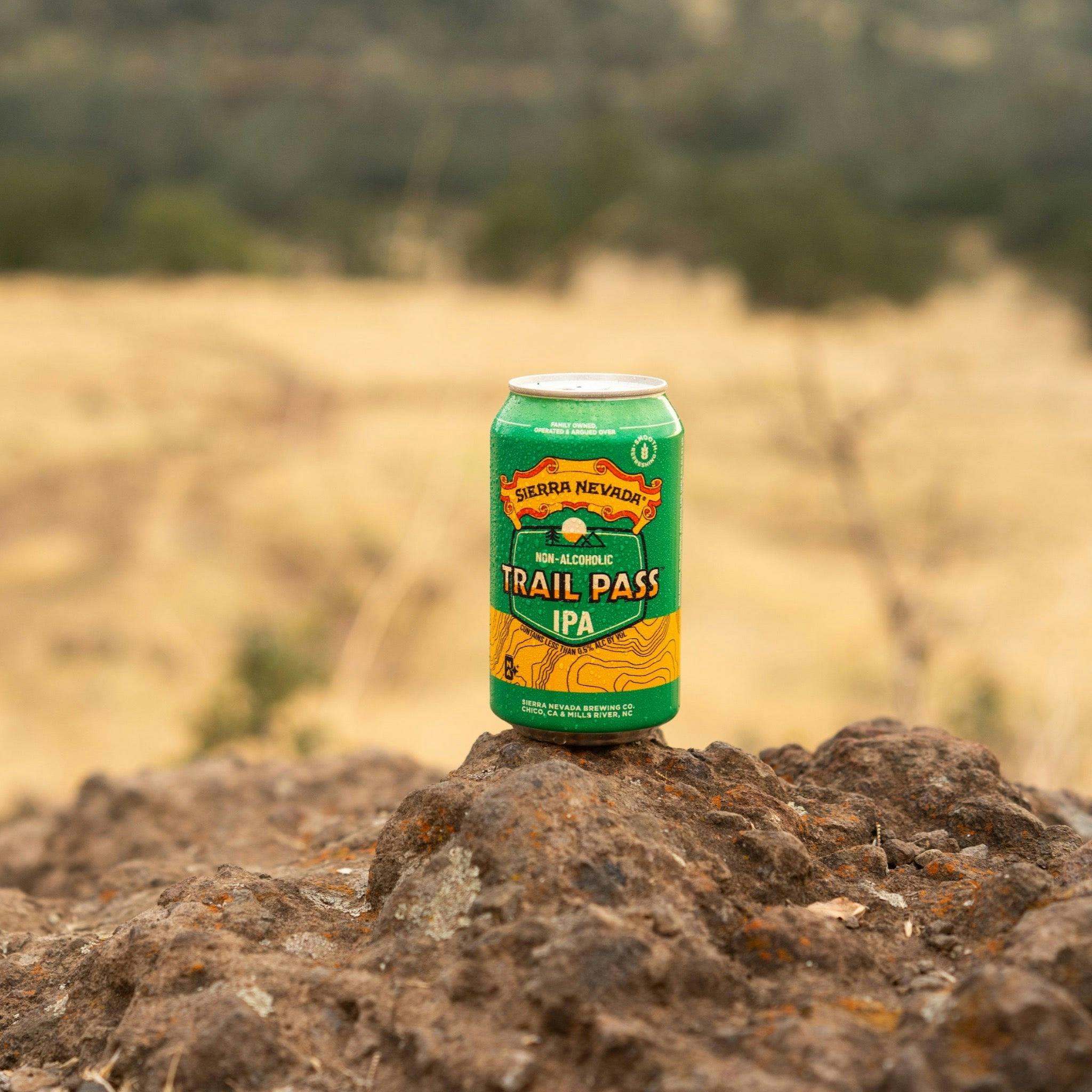Sierra Nevada Brewing Co. Trail Pass IPA Non-Alcoholic Brew - A chilled can of Trail Pass IPA rests on a rocky outcropping overlooking a field.