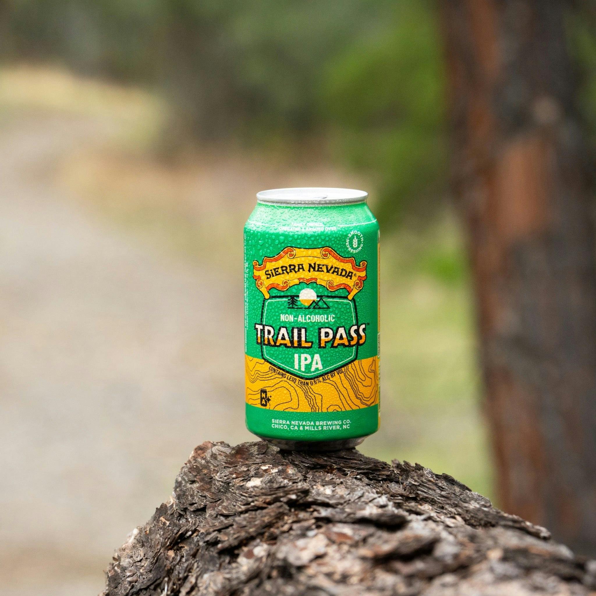 Sierra Nevada Brewing Co. Trail Pass IPA Non-Alcoholic Brew - A refreshing can of Trail Pass IPA rests on the end of a fallen log near a hiking trail.