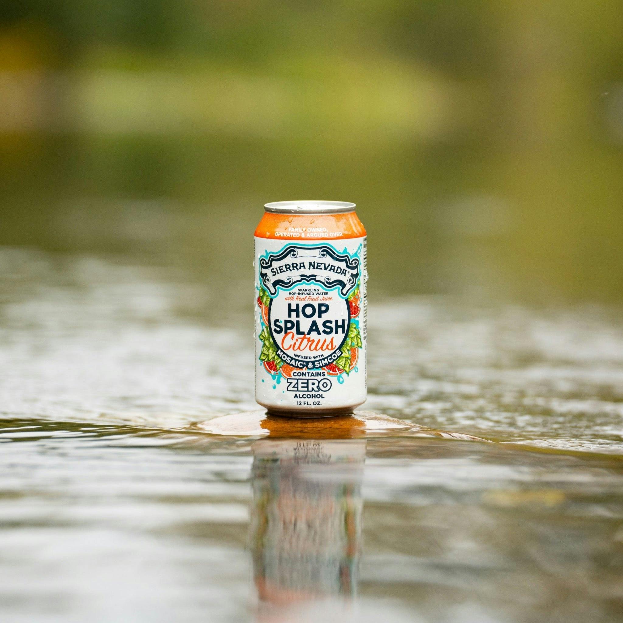 Sierra Nevada Brewing Co. Hop Splash Citrus Non-Alcoholic Sparkling Hop Water - A can of refreshing Hop Splash Citrus sits on a flat stone surrounded by a gently moving river