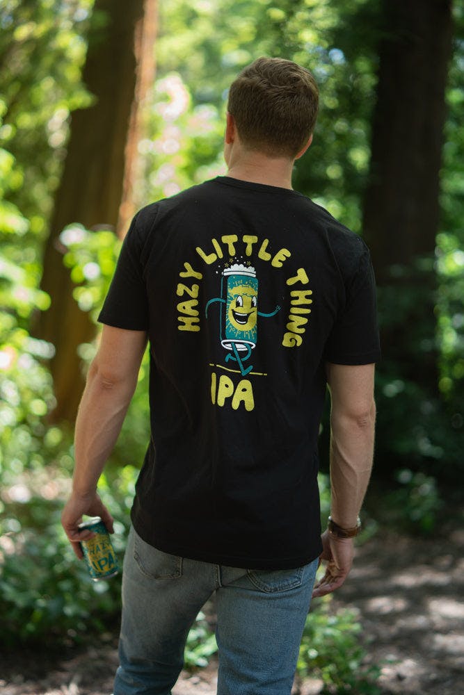 Sierra Nevada Brewing Co. Hazy Little Thing Psychedelic T-shirt back view as worn by a man standing in a wooded campground.