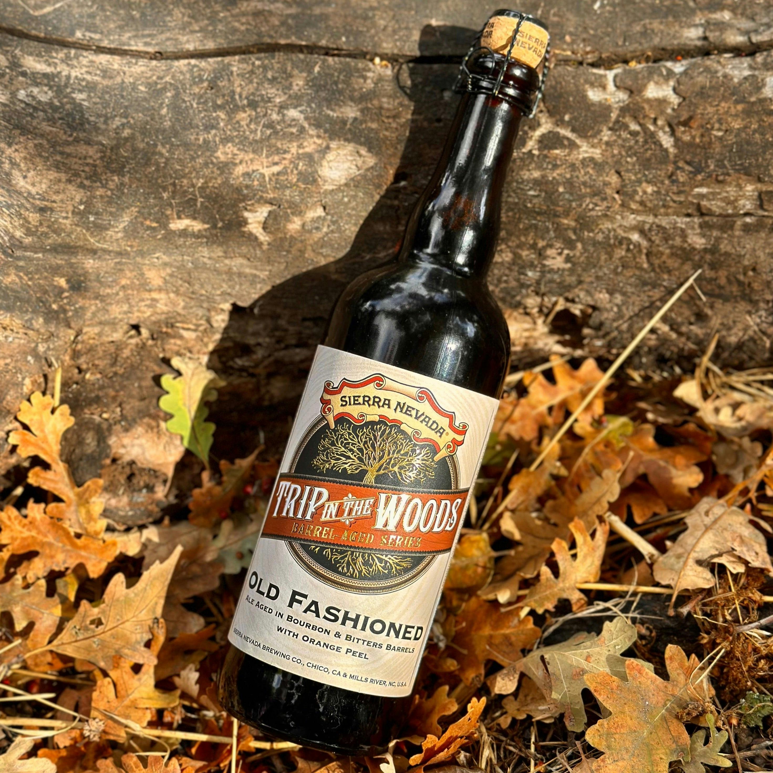 Sierra Nevada Brewing Co. Trip In The Woods Old Fashioned 750 mL bottle in a fall setting with colorful leaves