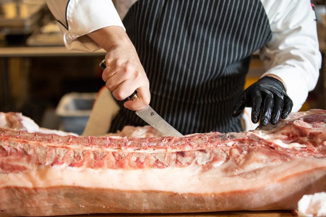 a large cut of meat being portioned