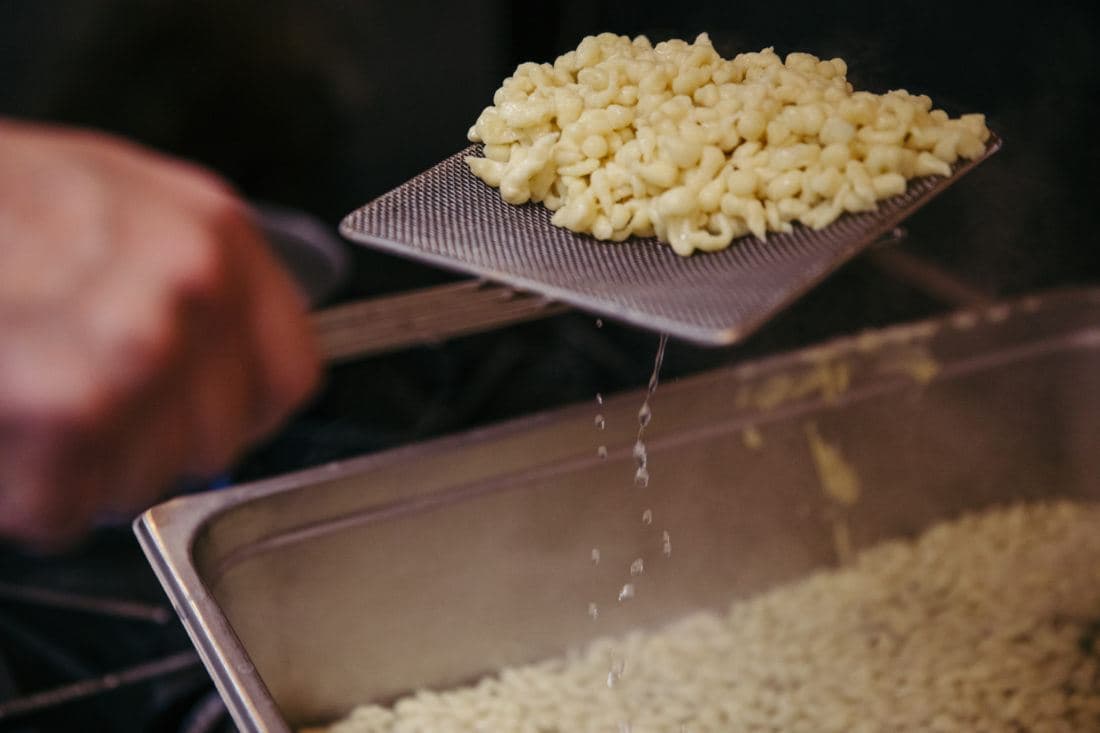 Scooping spaetzle and draining out the liquid