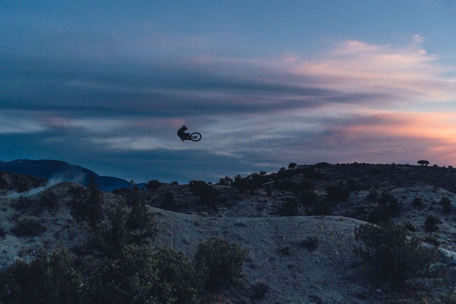 Guy going over a jump on a mountain bike