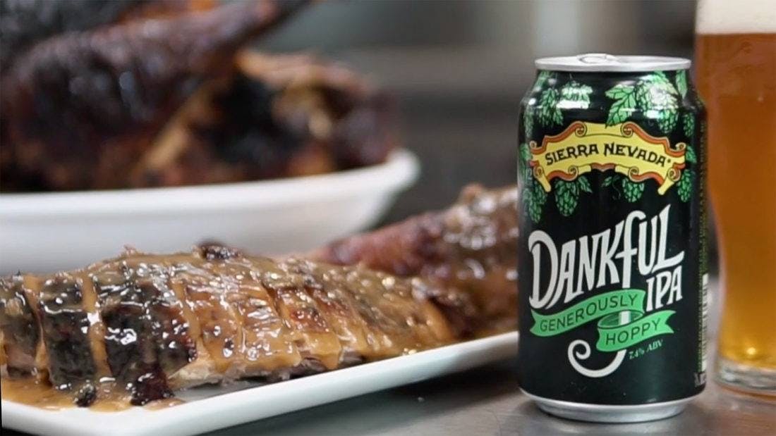 Serving platter of roasted meat next to a can of Dankful IPA beer