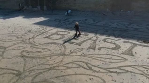 Sharon Belknap creates art in the sand on the beach