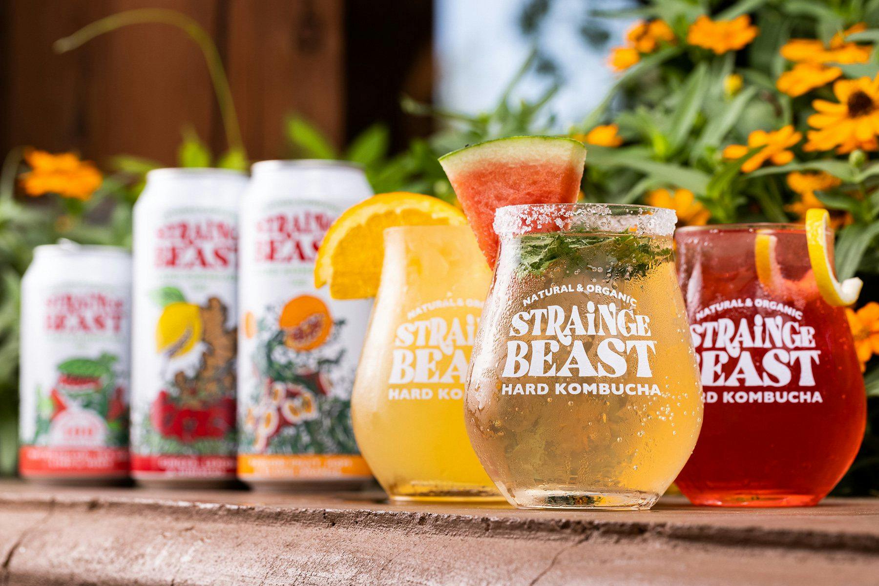 Three glasses of different Strainge Beast flavors, all garnished with fruit