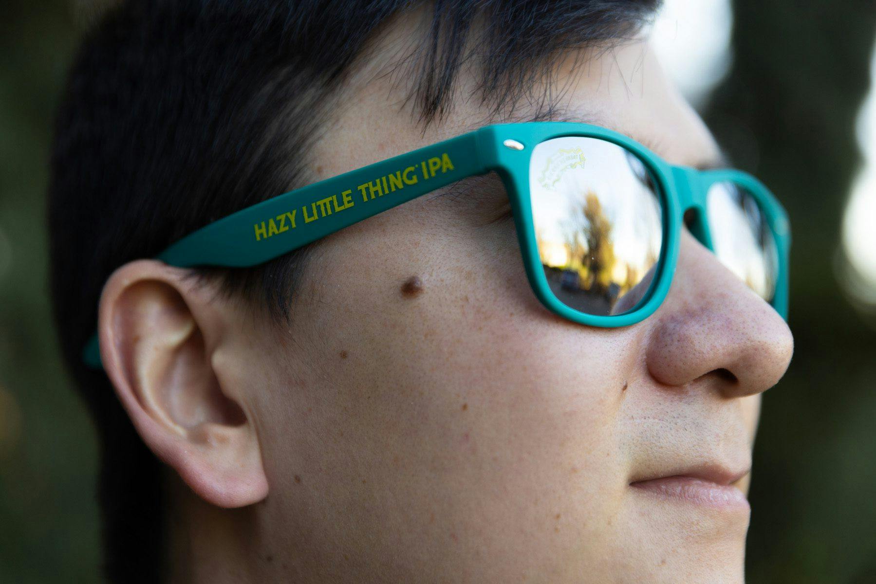 Young man wearing Hazy Little Thing IPA sunglasses