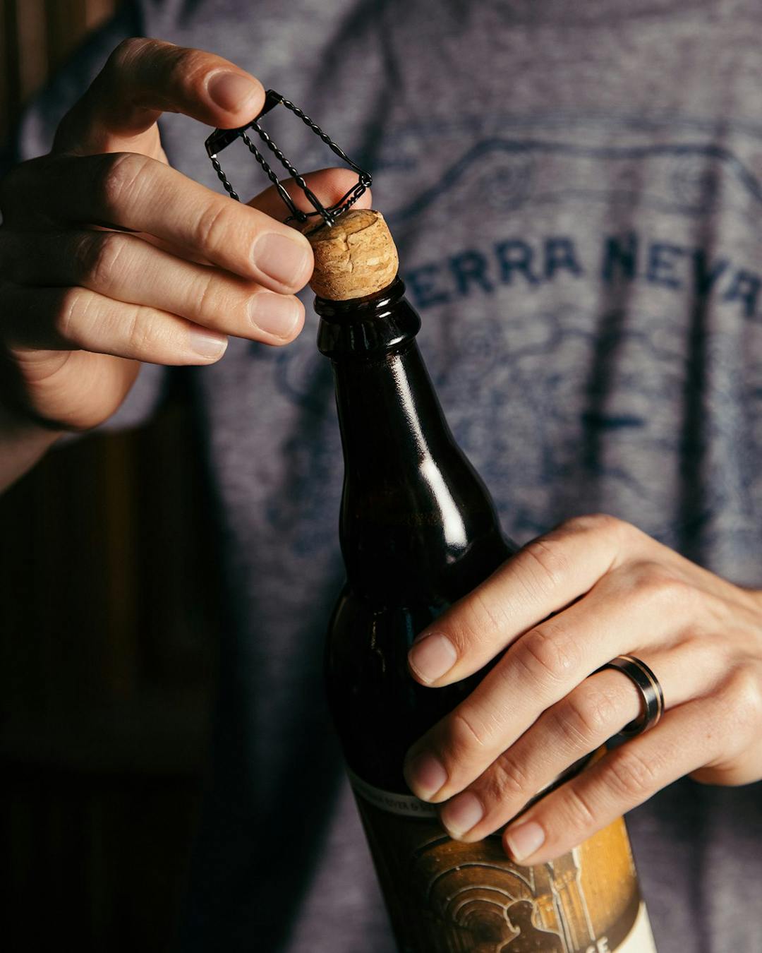 Removing the wire cage on a corked bottle of beer